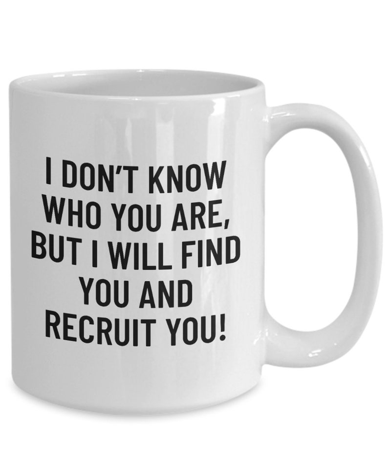 May include: White ceramic mug with a curved handle. The mug features black text that reads: "I DON'T KNOW WHO YOU ARE, BUT I WILL FIND YOU AND RECRUIT YOU!" A humorous gift for a recruiter or hiring manager.