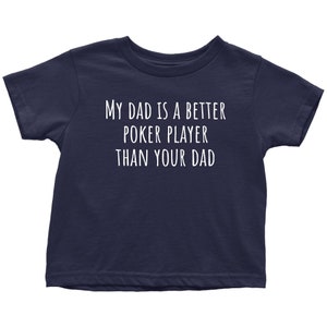 May include: A navy blue toddler t-shirt with white text that reads "My Dad is a Better Poker Player Than Your Dad."