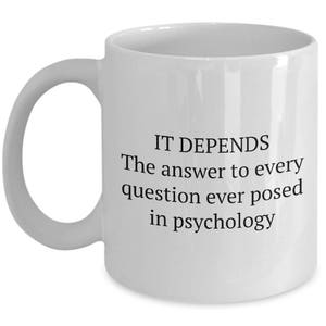 May include: White ceramic coffee mug with black text that reads "IT DEPENDS The answer to every question ever posed in psychology."