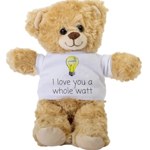 May include: A brown teddy bear wearing a white t-shirt with a lightbulb graphic and the text "I love you a whole watt".