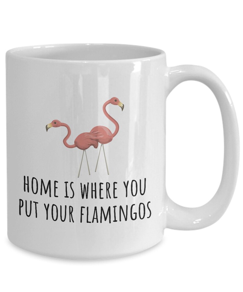 May include: White ceramic coffee mug with a pink flamingo illustration and the text "Home is where you put your flamingos".