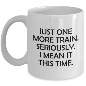 May include: White ceramic coffee mug with black text that reads "Just one more train. Seriously. I mean it this time."