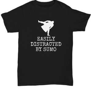 May include: Black t-shirt featuring a white sumo wrestler graphic and the text "EASILY DISTRACTED BY SUMO". The shirt has a crew neck and short sleeves.