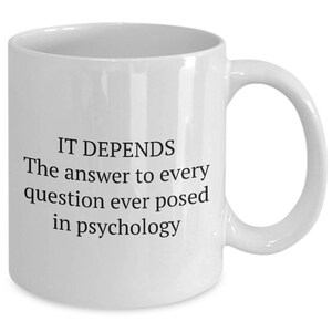 May include: White ceramic mug with black text that reads "IT DEPENDS The answer to every question ever posed in psychology"