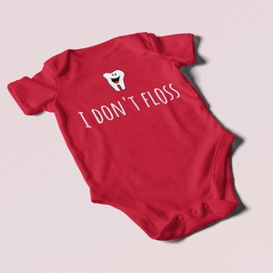 Peut inclure: Combinaison b&eacute;b&eacute; rouge avec une dent de dessin anim&eacute; blanche et le texte "Je ne passe pas de fil dentaire".
