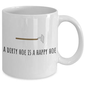 May include: White ceramic coffee mug with a black and brown illustration of a garden hoe and the text "A dirty hoe is a happy hoe".