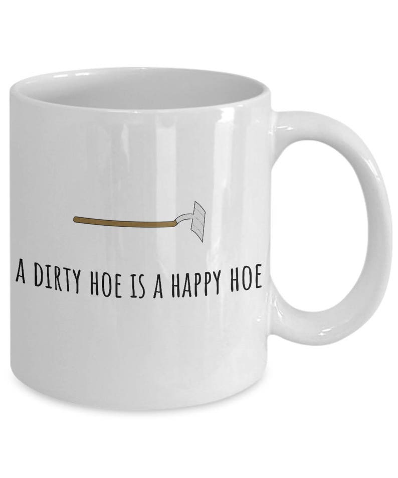 May include: White ceramic coffee mug with a black and brown illustration of a garden hoe and the text "A dirty hoe is a happy hoe".