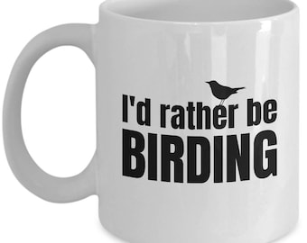 Puede incluir: Taza de café de cerámica blanca con una silueta negra de un pájaro y el texto "I'd rather be BIRDING".