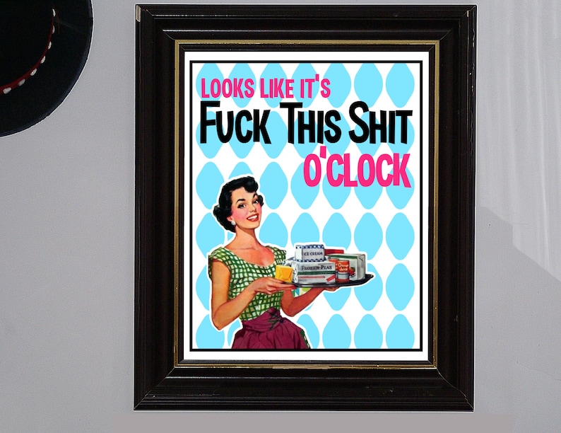 May include: A framed print with a retro-style illustration of a woman holding a tray of groceries. The text on the print reads "Looks like it's Fuck This Shit o'clock".