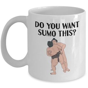 May include: White ceramic coffee mug with a black graphic of two sumo wrestlers and the text "Do you want sumo this?"
