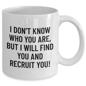 May include: White ceramic mug with a curved handle. The mug features black text that reads: "I DON'T KNOW WHO YOU ARE, BUT I WILL FIND YOU AND RECRUIT YOU!" A humorous gift for a recruiter or hiring manager.