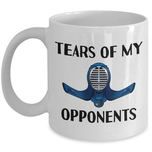 May include: White ceramic coffee mug with a black graphic of a kendo mask and the text "Tears of my opponents".