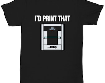 Könnte beinhalten: Ein schwarzes Kurzarm-T-Shirt mit einer weißen Grafik eines 3D-Druckers und dem Text "I'D PRINT THAT" in einer fetten, serifenlosen Schrift, die über der Druckerillustration zentriert ist. Das Druckermotiv zeigt einen grauen Rahmen und eine orange Düse.