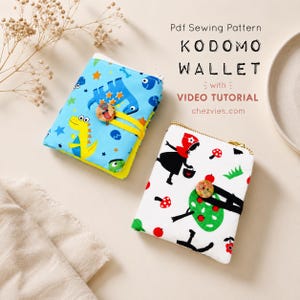 May include: Two fabric wallets with button closures. One is light blue with a yellow, blue, and green dinosaur print. The other is white with a red, black, and green print of a figure in a hood, mushrooms, and apples. Text reads: Pdf Sewing Pattern KODOMO WALLET with VIDEO TUTORIAL chezvies.com.