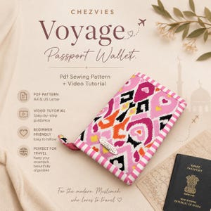 May include: A rectangular passport wallet featuring a vibrant pink, orange, yellow, and black ikat-style pattern with a pink and white striped border. The wallet includes a silver-toned metal tag labeled CHEZVIES and a matching fabric zipper pull.