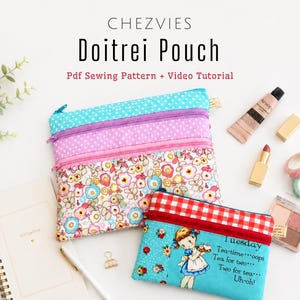 May include: Three zippered pouches with floral, polka dot, and patterned designs. The pouches are in shades of blue, pink, and red. The text "Doitrei Pouch" is at the top, with "Pdf Sewing Pattern + Video Tutorial" below. A small pouch has a girl illustration and the text "Tuesday Tea-time...oops Tea for two... Two for tea... Uh-oh!"
