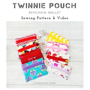 May include: A collection of small rectangular fabric pouches with zippers and metal keychains. The pouches feature various colorful patterns including red waves, cartoon characters, strawberries, and geometric shapes. Text reads TWINNIE POUCH.