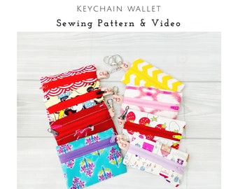May include: A collection of small rectangular fabric pouches with zippers and metal keychains. The pouches feature various colorful patterns including red waves, cartoon characters, strawberries, and geometric shapes. Text reads TWINNIE POUCH.