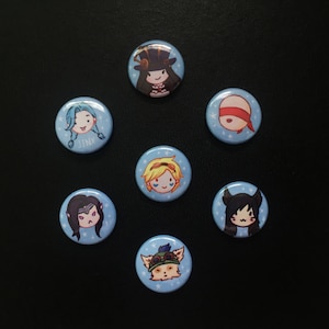 May include: Seven round blue and white buttons with cartoon character images. The characters are a girl with blue hair, a girl with blonde hair, a girl with black hair, a girl with a hat, a girl with a blindfold, a girl with a cat mask, and a girl with a cat mask.