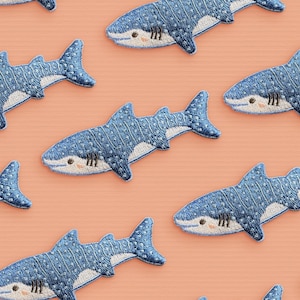 Può includere: Un set di dieci toppe ricamate a forma di squalo balena blu e bianco. Le toppe sono perfette per aggiungere un tocco di fantasia a vestiti, borse o altri accessori.
