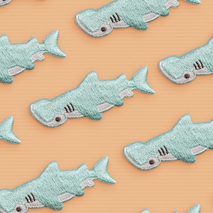 Peut inclure: Un ensemble de dix patchs brodés de requins marteaux bleus. Les patchs sont parfaits pour ajouter une touche nautique aux vêtements, aux sacs ou à d'autres accessoires.