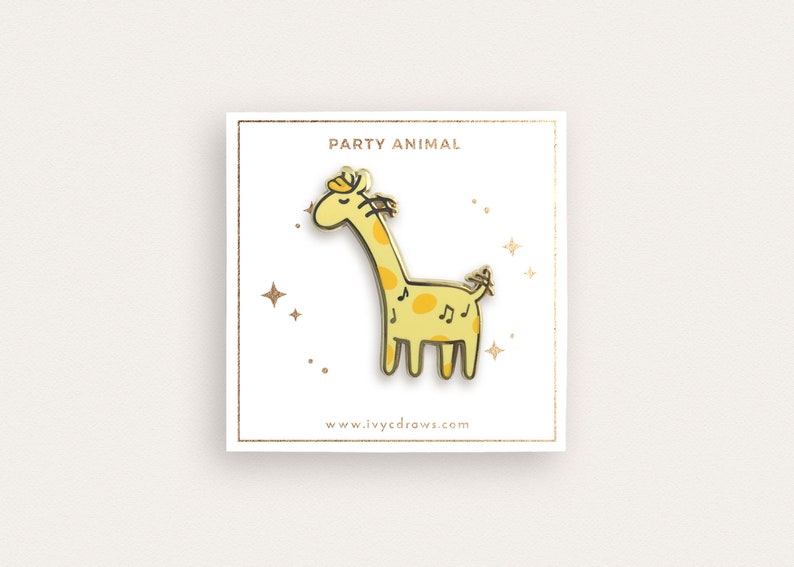 May include: A gold-colored enamel pin featuring a cartoon giraffe with musical notes on its body. The pin says "Party Animal" and "www.ivycdraws.com".