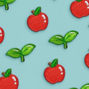 May include: A blue background with a repeating pattern of red apples and green leaves. The apples are embroidered with a simple design and have a shiny finish.