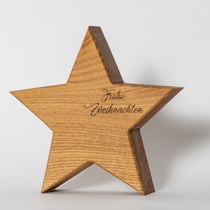 Può includere: Un ornamento a forma di stella in legno con la scritta "Frohe Weihnachten" incisa su di esso.