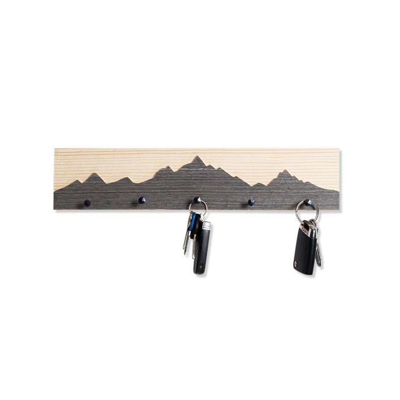 K&ouml;nnte beinhalten: Schl&uuml;sselhalter aus Holz mit einer Silhouette einer Bergkette. Der Halter hat vier Haken zum Aufh&auml;ngen von Schl&uuml;sseln.