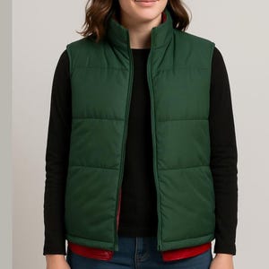 May include: A green puffer vest with a red interior lining. The vest has a high collar and a full-length zipper. The vest is worn over a black long-sleeved shirt.