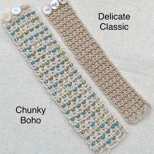 K&ouml;nnte beinhalten: Zwei Perlenarmb&auml;nder, eines im dicken Boho-Stil und das andere im zarten klassischen Stil. Das dicke Armband hat gr&uuml;ne und blaue Perlen, w&auml;hrend das zarte Armband goldene Perlen hat. Beide Armb&auml;nder haben wei&szlig;e Kn&ouml;pfe.