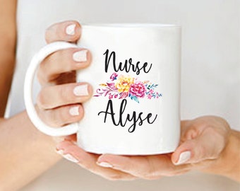 May include: White ceramic mug with a black floral design and the text "Nurse Alyse".