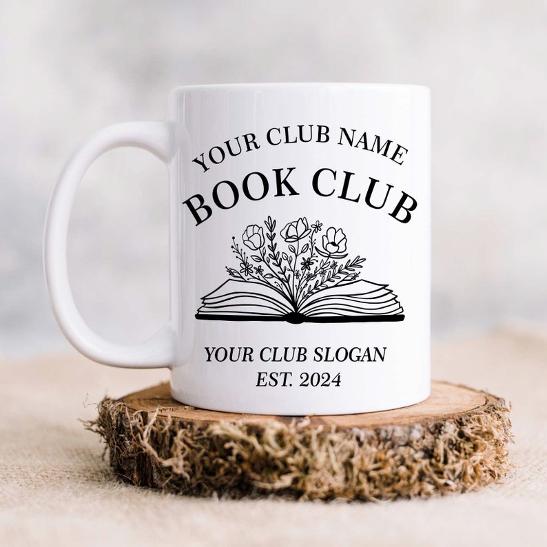 May include: White ceramic mug with a black design that says "Your Club Name Book Club" with a stylized open book with flowers coming out of it. Below the book is the text "Your Club Slogan Est. 2024".