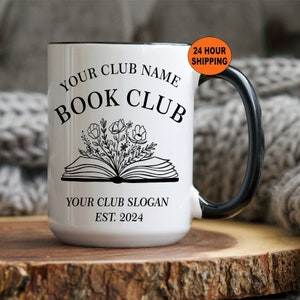 May include: White ceramic mug with a black rim and handle. The mug has a black design of an open book with flowers growing out of it. The text "Your Club Name Book Club" is above the book and "Your Club Slogan Est. 2024" is below the book.