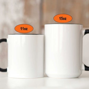 May include: Two white ceramic mugs with black handles. The mug on the left is 11 oz and the mug on the right is 15 oz.