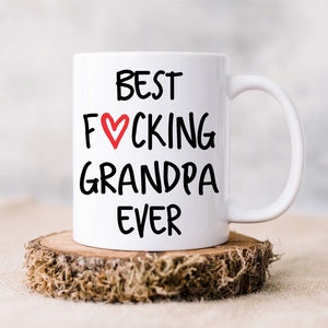 Op de afbeelding: Witte keramische mok met zwarte tekst die "Best F&hearts;cking Grandpa Ever" luidt.