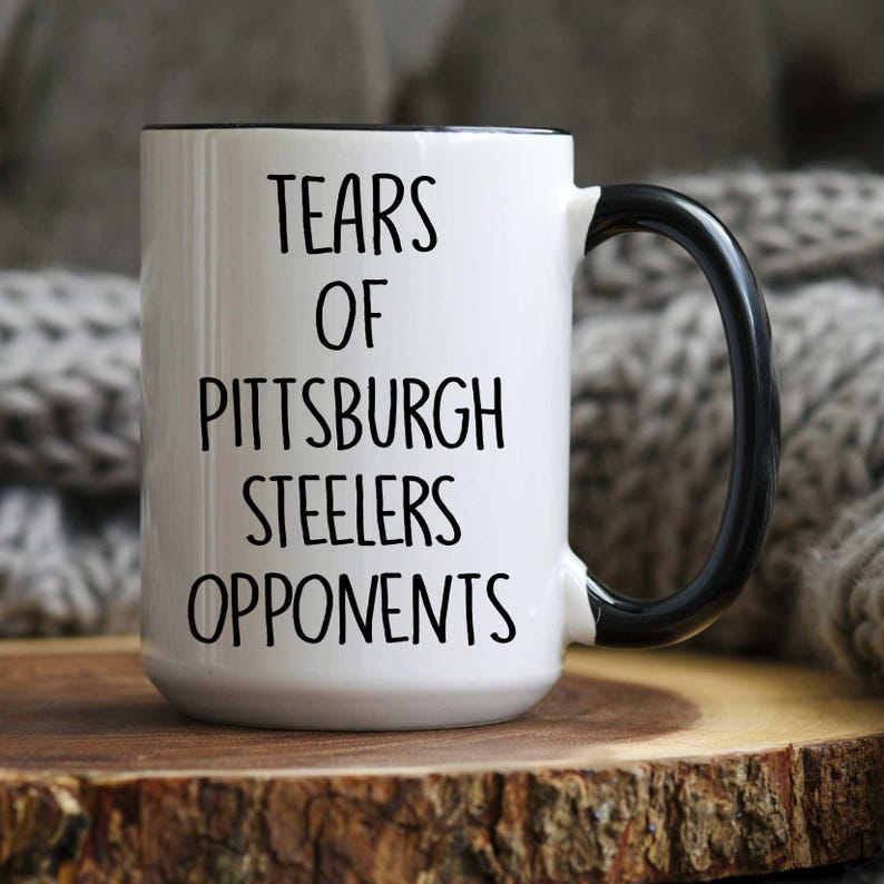 K&ouml;nnte beinhalten: Eine wei&szlig;e Keramik-Kaffeetasse mit schwarzem Henkel und schwarzem Text, der "Tears of Pittsburgh Steelers Opponents" lautet.
