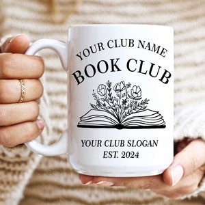 May include: White ceramic mug with a black design of an open book with flowers growing out of it. The text "YOUR CLUB NAME BOOK CLUB YOUR CLUB SLOGAN EST. 2024" is printed on the mug.