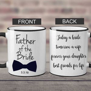 Puede incluir: Taza de caf&eacute; de cer&aacute;mica blanca con borde y asa negros. El frente de la taza dice "Father of the Bride" con una pajarita negra y la fecha "3.3.19". La parte posterior de la taza dice "Today a bride tomorrow a wife forever your daughter best friends for life".