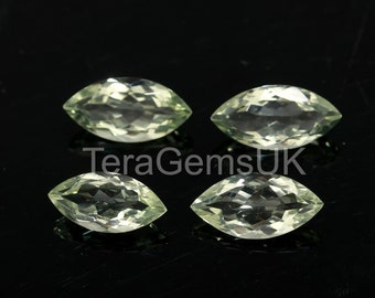 May include: Four marquise-shaped green gemstones on a black background. The gemstones are faceted and have a clear, glassy appearance.