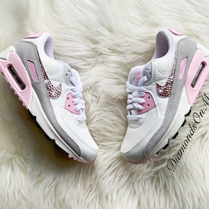May include: White and grey Nike Air Max 90 sneakers with pink accents and rhinestones on the swoosh logo. The text "Diamonds On My Feet" is visible on the right shoe.