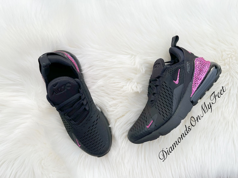 May include: Black Nike Air Max 270 sneakers with pink rhinestones on the back and side. The shoes are on a white fluffy surface. "Diamonds On My Feet" is written in the bottom right corner.
