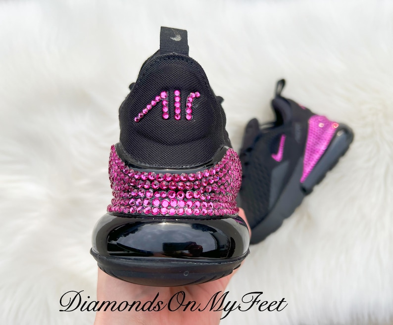 May include: Black Nike Air Max 270 sneakers with pink rhinestones covering the entire shoe. The Air Max logo on the back of the shoe is also covered in pink rhinestones.