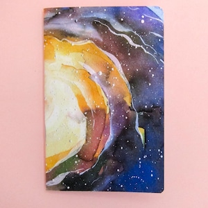 May include: Watercolour painting of a galaxy with swirling colours of yellow, orange, blue, and purple. The galaxy is painted on a white background.