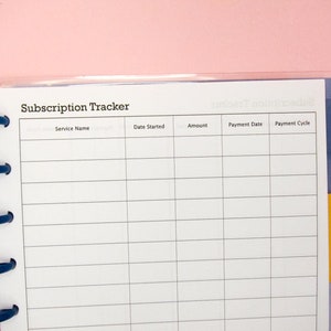 May include: A white page with a blue binder and a yellow tab. The page is titled "Subscription Tracker" and has columns for service name, date started, amount, payment date, and payment cycle.