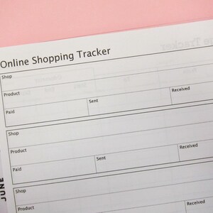 Puede incluir: Una hoja de papel blanca con una cuadrícula negra y el texto "Online Shopping Tracker" en la parte superior. La hoja está dividida en columnas etiquetadas como "Shop", "Product", "Paid", "Sent", y "Received".
