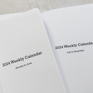 May include: Two blank, white paperback books with black text on the covers. The book on the left says "2024 Weekly Calendar January to June". The book on the right says "2024 Weekly Calendar July to December".