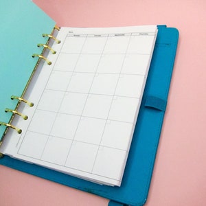 May include: A blue and turquoise planner with gold rings and a weekly calendar layout. The planner is open to a blank page with the days of the week labelled at the top.