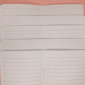 May include: A stack of blank notebooks with different page styles, including lined, grid, and plain pages. The notebooks are white and have a simple design.