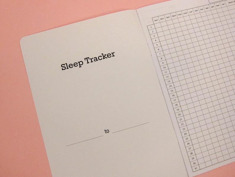Pu&ograve; includere: Un quaderno bianco con le parole "Sleep Tracker" stampate sulla copertina. Il quaderno ha una pagina a griglia per tenere traccia dei modelli di sonno.